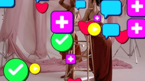 Fashion set two models posing around ladder while icons spawning from front Stock Footage 333413871