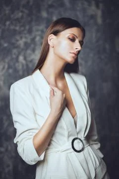 Fashion shot of a beautiful  young woman wearing elegant white suit on a grun Stock Photos