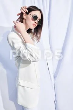 Fashion shot. Beautiful young woman model posing outdoor in white clothes amo Stock-Fotos