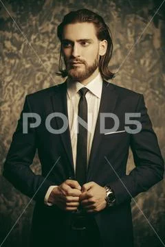 Fashion shot. Handsome young man posing in elegant suit and white shirt over Stock Photos