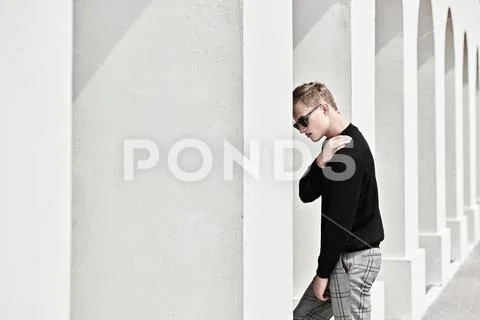 Fashion shot. Handsome young man model in black pullover, plaid trousers and Stock-Fotos