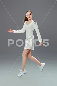 Fashion shot. Portrait of a beautiful young woman in a white dress running on Stock-Fotos