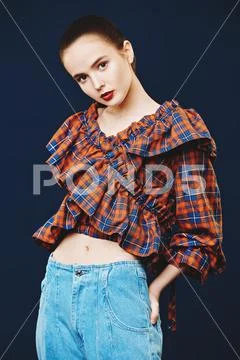Fashion shot. Portrait of a cute girl model posing in jeans and checkered bl Stock-Fotos