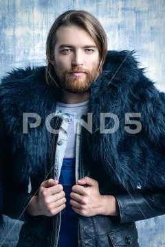 Fashion shot of a stylish brutal bearded man wearing fur coat. Studio shot ov Stock Photos
