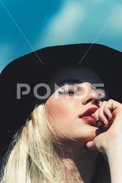 Fashion woman model pose outdoor. Girl on sunny blue sky background in summer Stock Photos