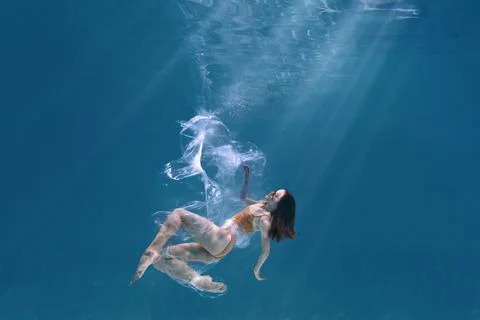 Fashionable and athletic girl free diver alone in the depths of the ocean. Sw Stock Photos