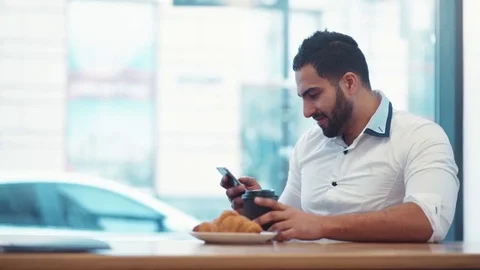 Fashionable bearded man drinking coffee, and sliding the screen of the phone Stock Footage