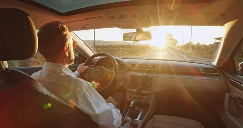 Fashionable retired business man driving car towards bright scenery sun pleasure Stock Footage