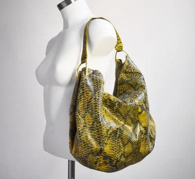 Fashionable snakeskin python handbag on mannequin in studio. 스톡 사진