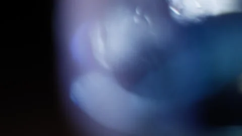 Fast abstract blurred liquid transition with a lens reflection on black Stock Footage 345518436