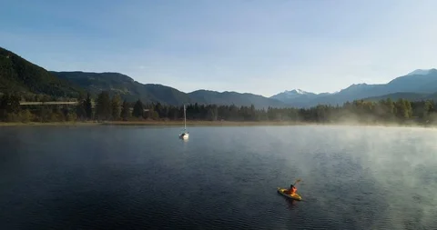 Fast Aerial Fly By Of Man Kayaking On A Misty Lake At Sunrise Stock-Footage 101041689
