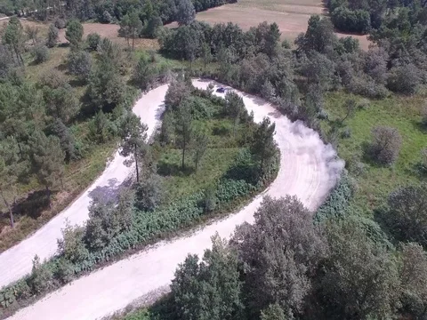 Fast Aerial fly by tracking shot of Subaru Rally car racing below Stock Footage 73471257