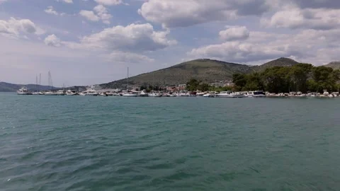 Fast aerial low fly over Adriatic bay with marina town near Trogir Croatia Stockbeeldmateriaal 337195273