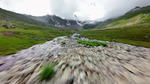 Fast aerial tracking shot over stream in green valley Video stock 345088492