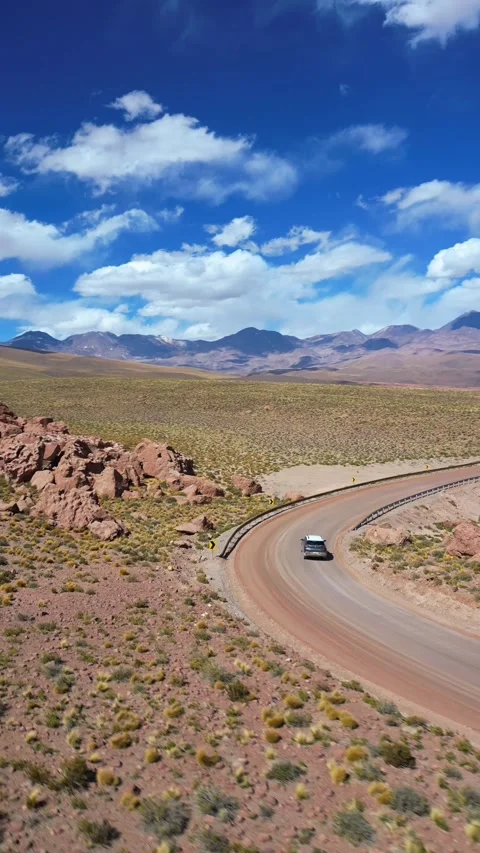 Fast aerial view of car navigating sharp mountain curve on paved road with Stockbeeldmateriaal 340930044