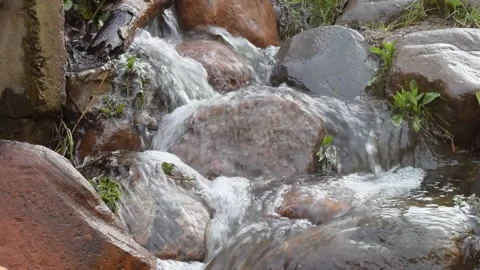 Fast and noisy stream flowing over the stones in the park Stock Footage 158060301