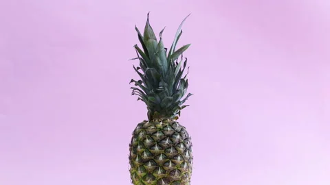 Fast and slowly pineapple rotating on pastel pink theme Stock Footage 141604265