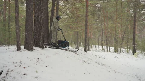 Fast ATV descent through forest. Rider swiftly navigating snowy pine trail Video stock 345144578