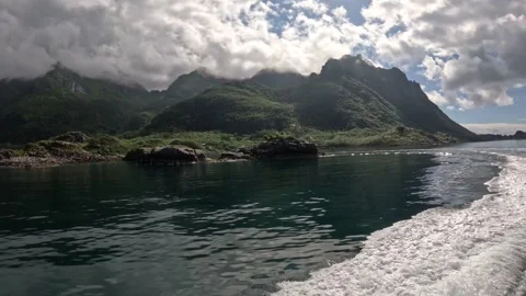 Fast boat wake navigating past dramatic mountain fjord coast in Lofoten Stock-Footage 344453297