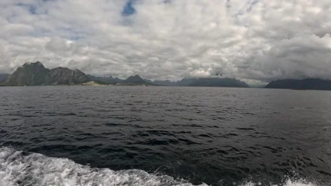 Fast boat wake in open sea with dramatic mountain range panorama Lofoten Stock-Footage 344047343