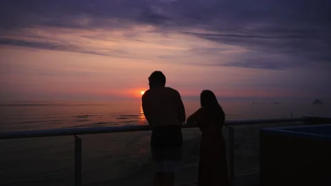 Fast camera a couple watching a beautiful sunset with a purple sky on a terrace Stock Footage 193100055