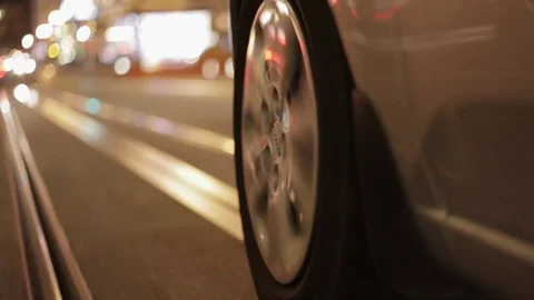 Fast car driving close up mount to tire in city at night Stock Footage 75736591