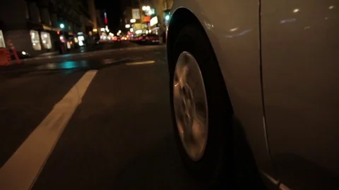 Fast car driving close up mount to tire at night Stock Footage 75736599