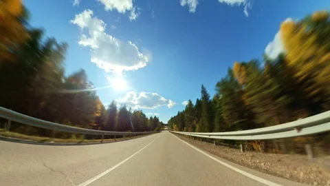 Fast car driving through a beautiful autumn forest on a curvy road Stock Footage 332749173