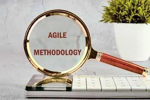 Fast changes concept. AGILE METHODOLOGY on the glass of a magnifying glass on Stock Photos