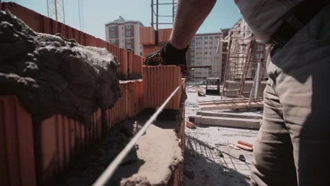 Fast close up trough the wall to a builder who place a bricks 스톡 동영상 143216474
