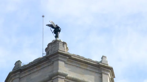 Fast clouds behind angel statueon roof protected by lightning rod Stock Footage 42180018
