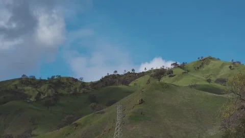 Fast clouds drift over the vibrant green hills near Winters, California Stock Footage 329203409