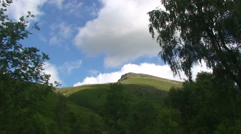 Fast clouds fly over mountain, framed by two trees Stock Footage 39987144