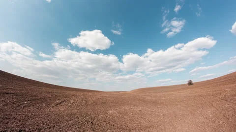 Fast clouds over farm land. Large agricultural field without plants. Stock Footage 151223824