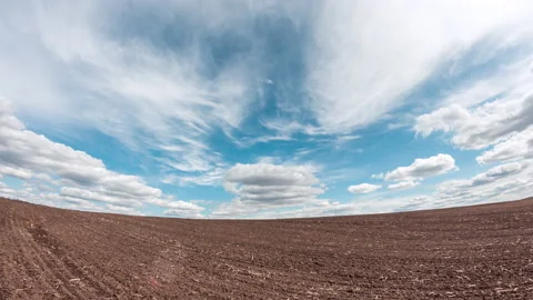 Fast clouds over farm land. Large agricultural field without plants Stock Footage 151609892