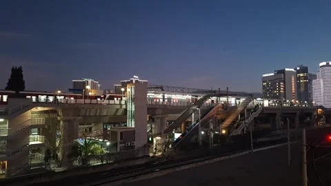Fast Commuter Train Passing at Night with Illuminated Lights Stock Footage 329748548