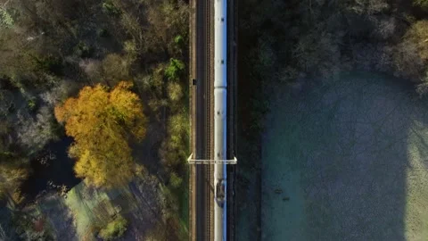 Fast Commuter Train Passing Over a Viaduct Bird's Eye View Stock Footage 230330417