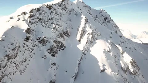 Fast, downward movement along a steep snowy mountain face Stock Footage 314417908