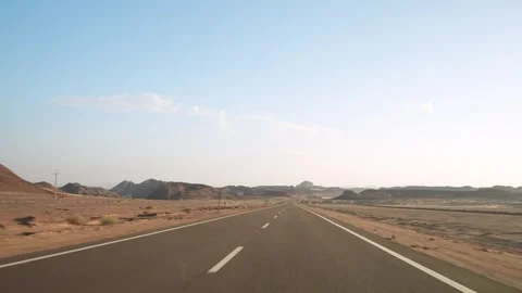 Fast driving on the empty asphalt road in the wild desert with road surface Stock Footage 251885531