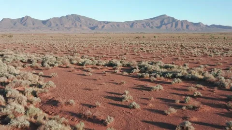 Fast drone shot above desert with Flinders Ranges mountains in background, Stock Footage 261789568