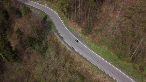 Fast drone tracking motorcycle through forest curve Stock Footage 332940592