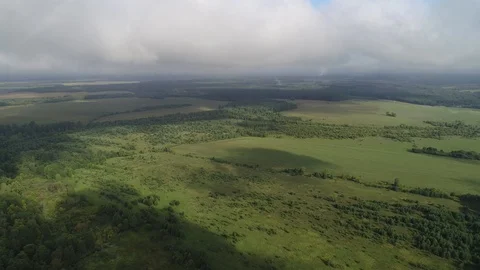Fast flight and rise through a layer of cumulus clouds. Plain rural landscape Stock Footage 116965225