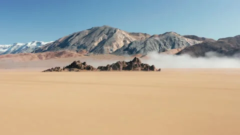 Fast flight around rocks on flat surface of ancient dry lake bed 4K aerial 스톡 동영상 136803231