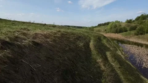 Fast flight low above the ground. View of hills and trees. No one around, sunny  Stock Footage 274405045