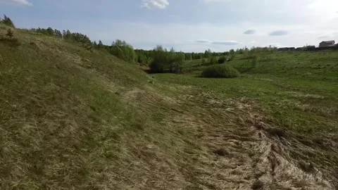 Fast flight low above the ground. View of hills and trees. No one around, sunny  Stock Footage 274405068
