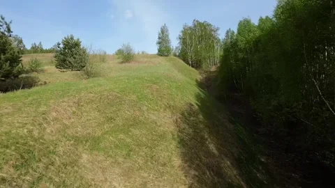 Fast flight low above the ground. View of hills and trees. No one around, sunny  Stock Footage 274405077
