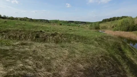 Fast flight low above the ground. View of hills and trees. No one around, sunny  Stock Footage 274405133
