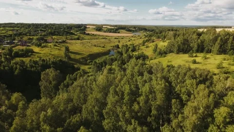 Fast flight low above the ground. View of fields and trees. No one around, sunny Stock Footage 280384205