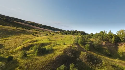 Fast flight low above the ground. View of fields and trees. No one around, sunny Stock Footage 280384241