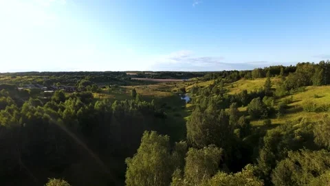 Fast flight low above the ground. View of fields and trees. No one around, sunny Stock Footage 280384455